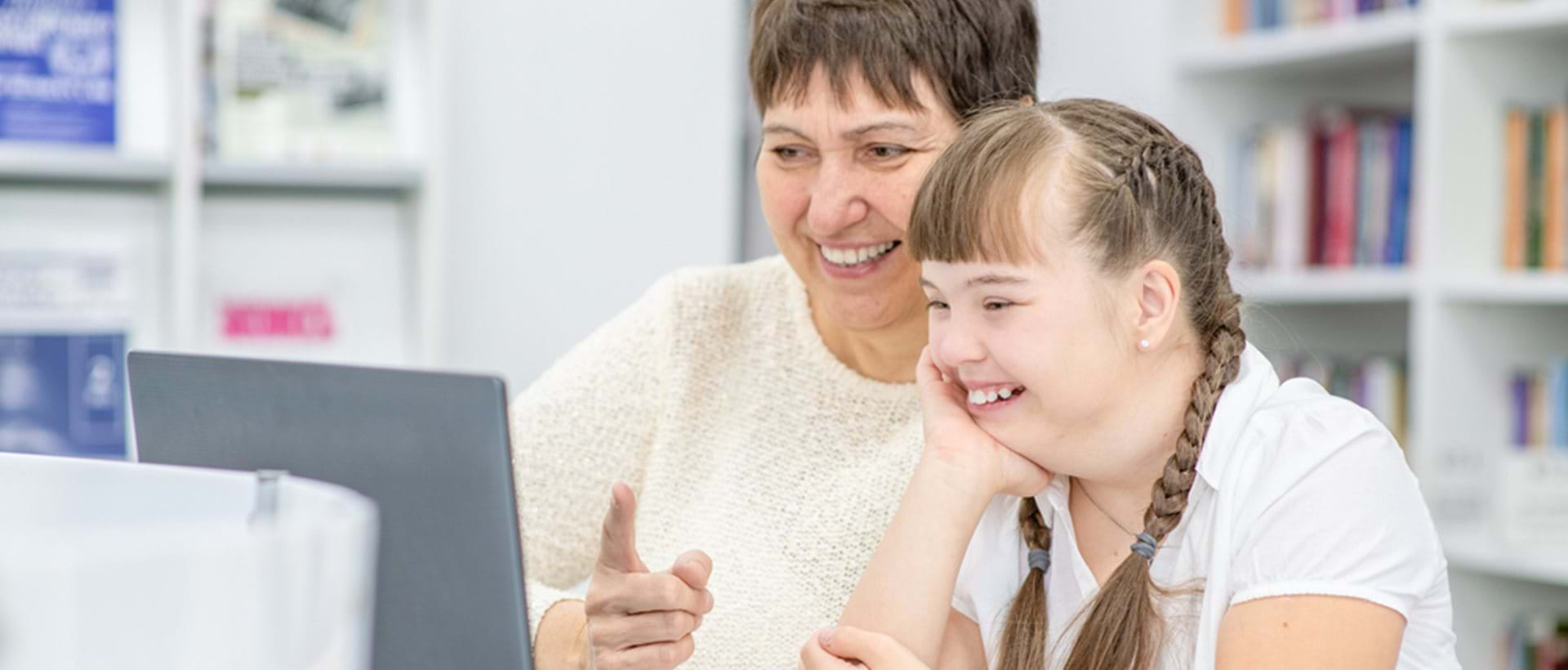 En voksen og et barn sitter ved en datamaskin sammen