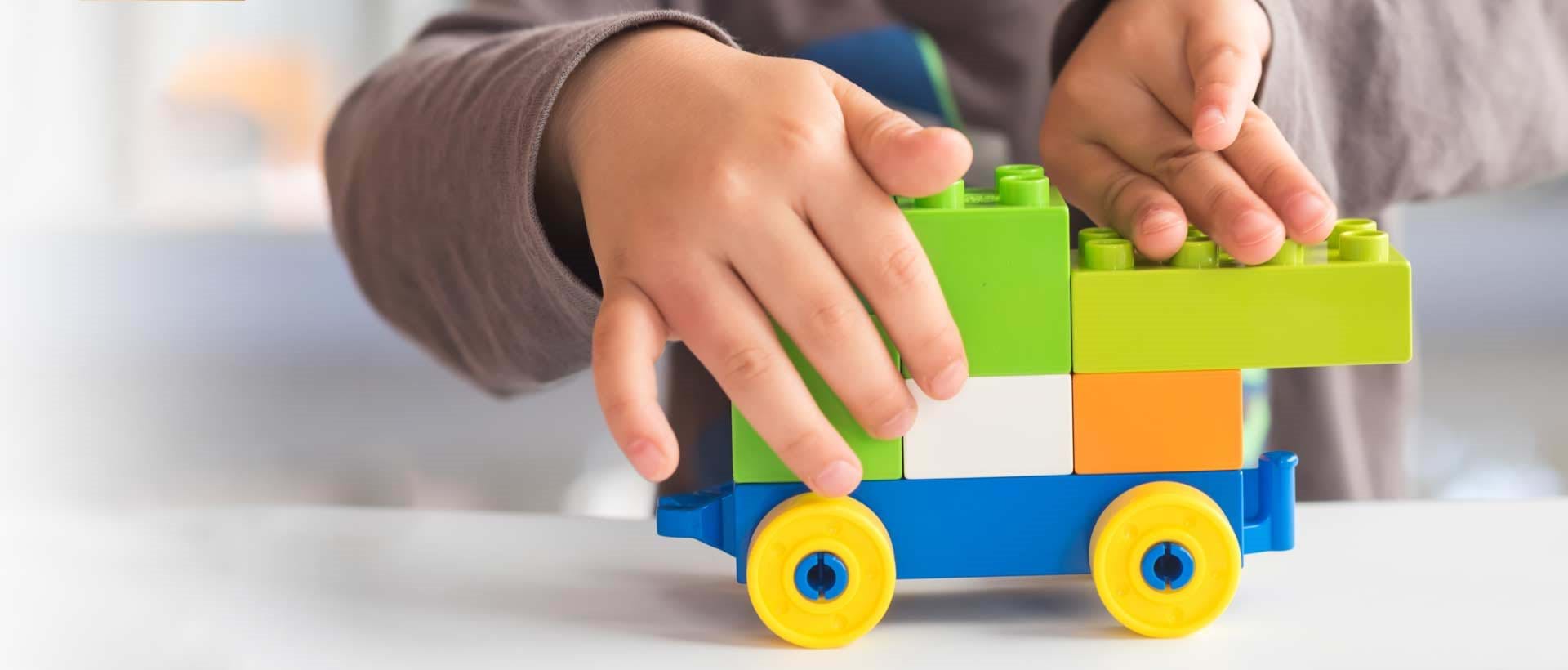 IUP - Individuell Utviklingsplan: Et barn som leker med legoklosser, symboliserer individuell utvikling og læring.