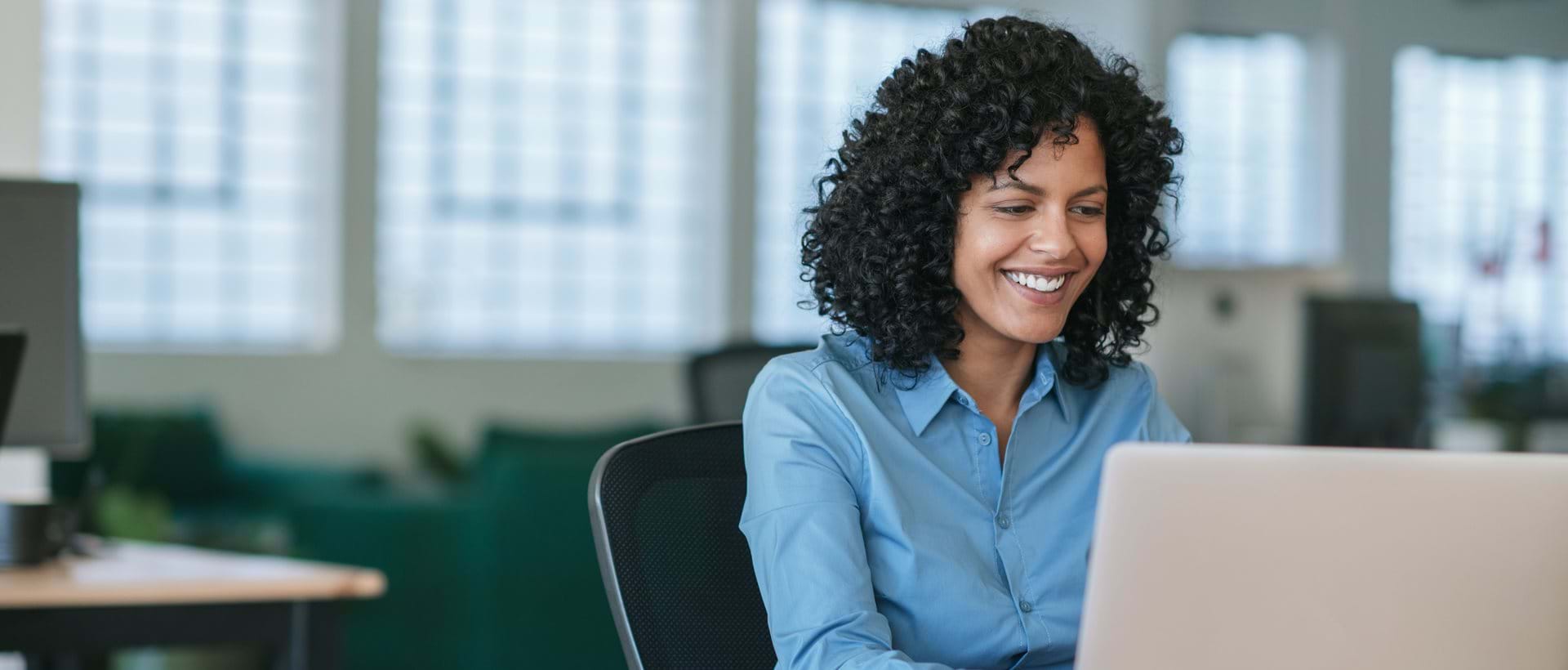 Kvinnelig HR-leder ser på webinar om å jobbe med strategisk HR på laptop på kontoret