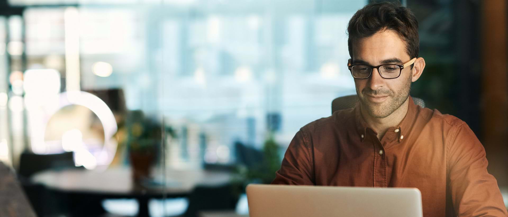 Mannlig HR-leder ser på webinar om å jobbe datadrevet med HR på laptop på kontoret